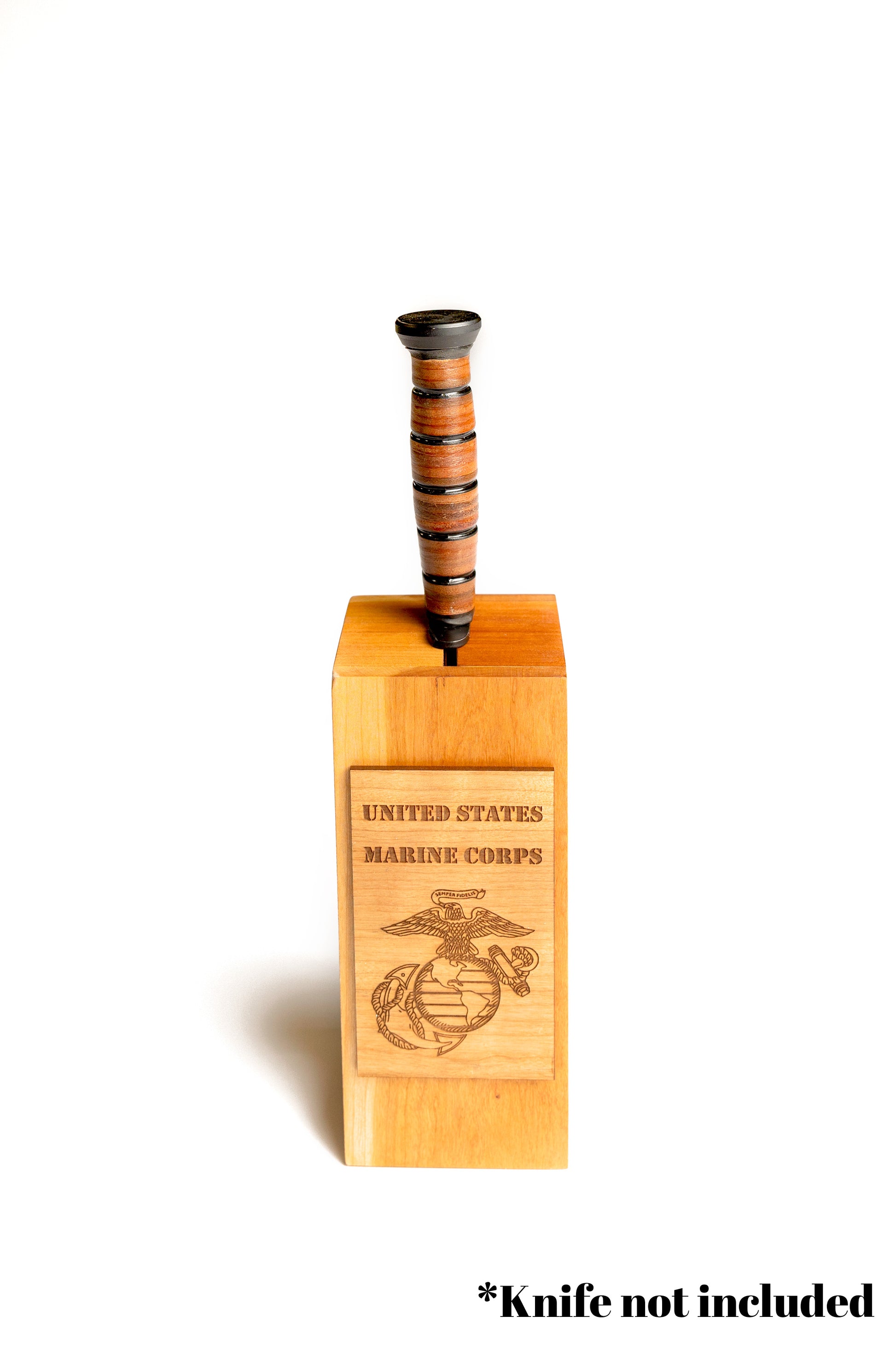 A Ka-Bar knife displayed in a solid cherry wood block on an office bookshelf, serving as a proud veteran's memento.