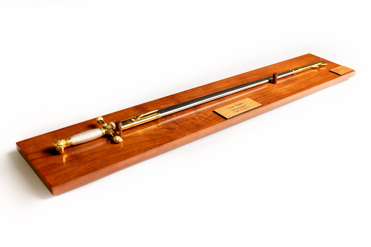 The Citadel Saber Display in Cognac finish with a personalized engraved nameplate, shown with a cadet sword.